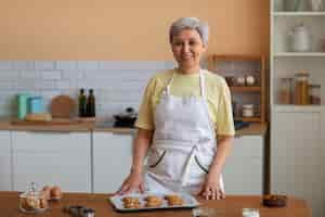 Free photo medium shot senior woman cooking at home