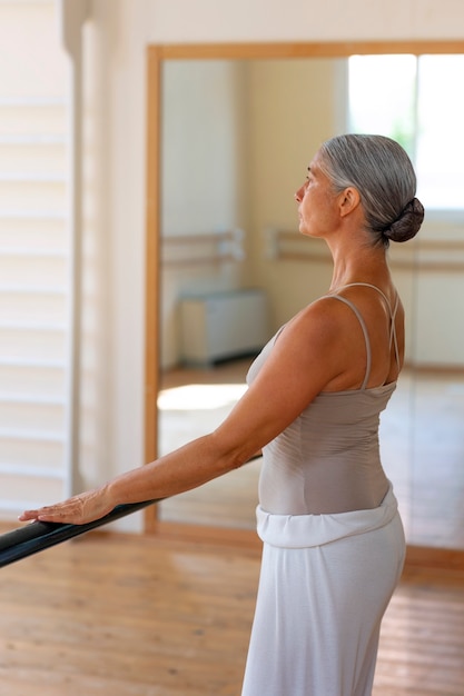 Free photo medium shot senior woman dancing in studio