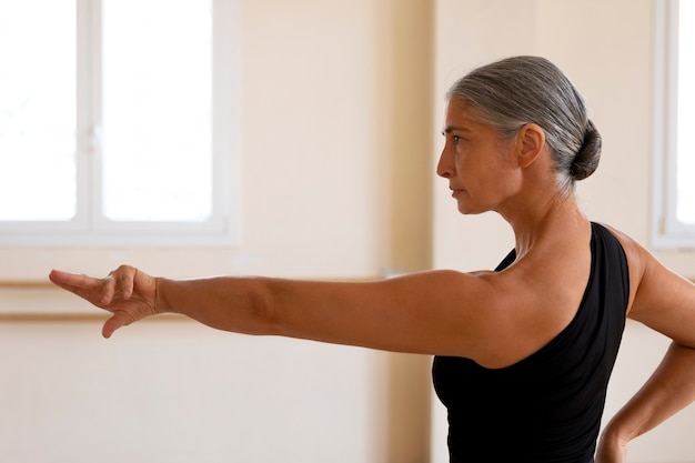 Free photo medium shot senior woman dancing in studio