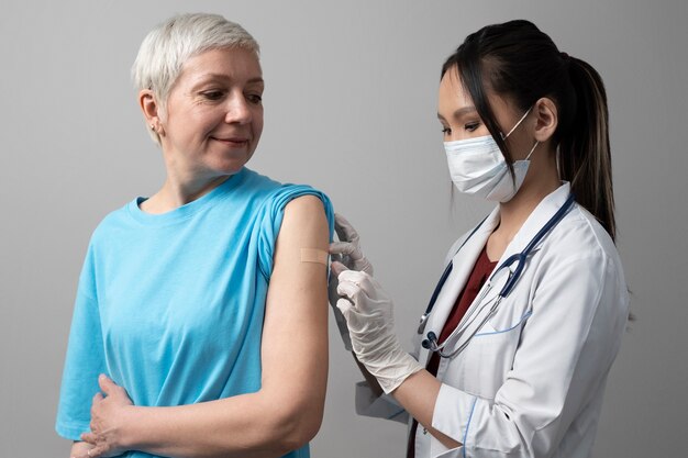 ワクチン接種を受けるミディアムショットの年配の女性