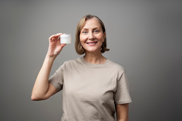 Medium shot senior woman holding container