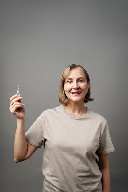 Medium shot senior woman holding vial