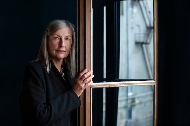 Free photo medium shot senior woman posing indoors