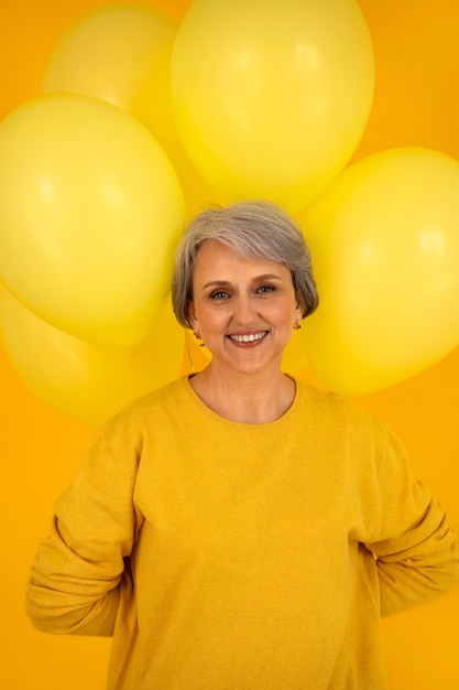 Medium shot senior woman posing with balloons