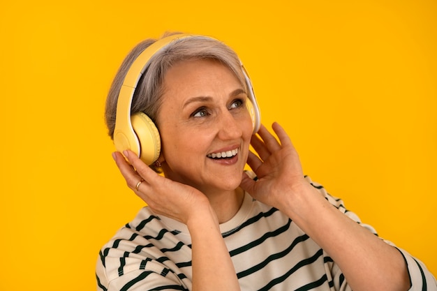 Medium shot senior woman posing with headphones