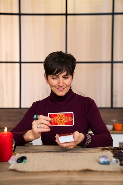 Medium shot senior woman reading tarot