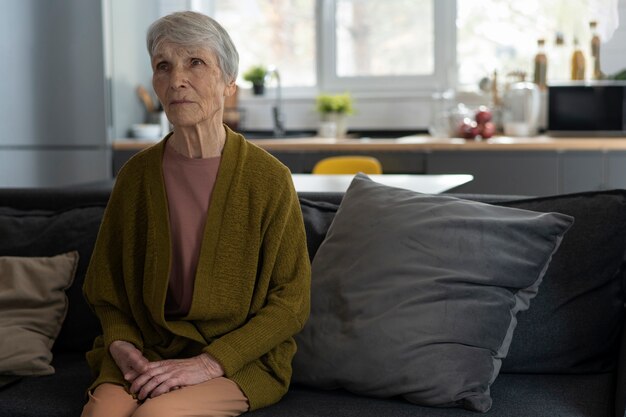 Medium shot senior woman sitting on couch