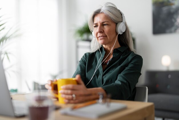 Medium shot senior woman wearing headphones