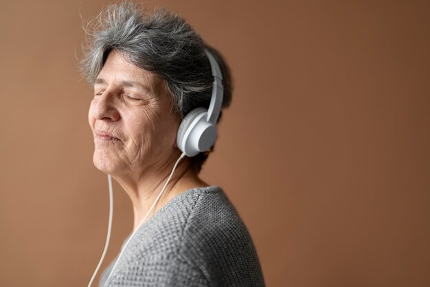 Medium shot senior woman with headphones