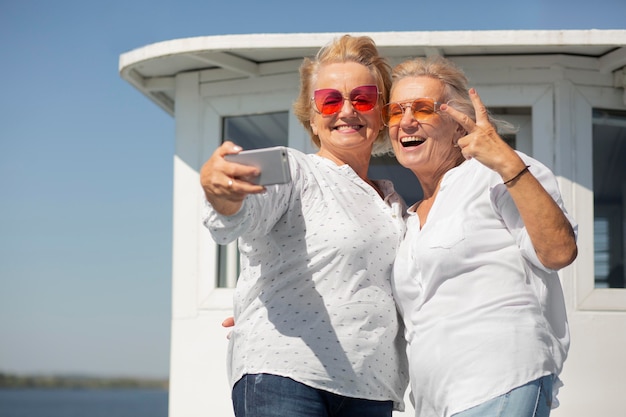 Free photo medium shot senior women taking selfie