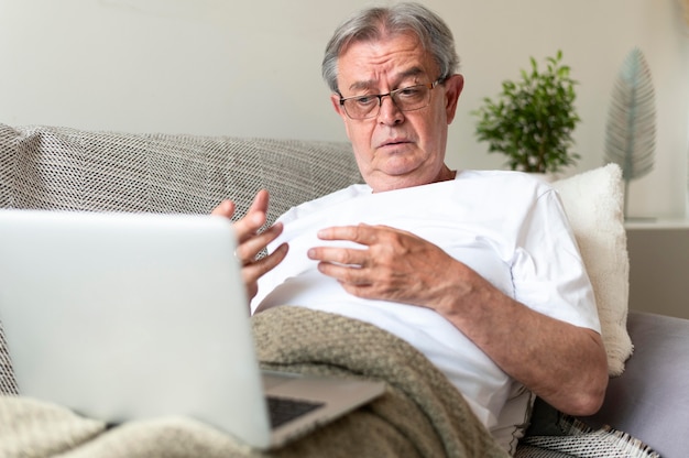 Medium shot sick man on couch