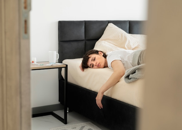 Medium shot sick woman in bed