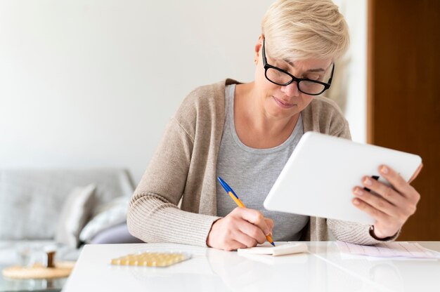 Medium shot sick woman with tablet