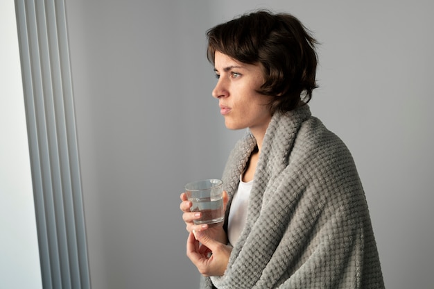 Foto gratuita donna malata colpo medio con bicchiere d'acqua