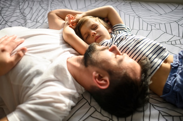 medium shot sleeping father and son