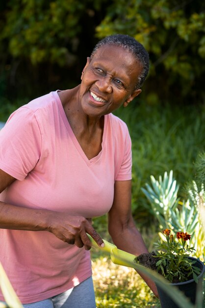 Medium shot smiley black woman gardening