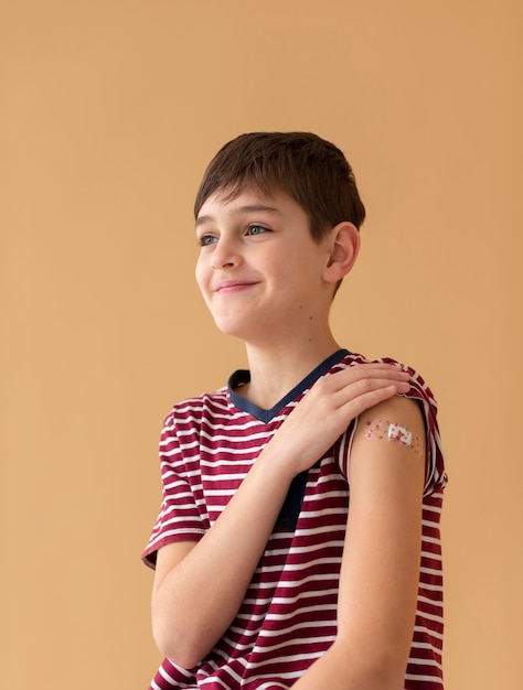 Улыбающийся мальчик среднего размера после вакцинации