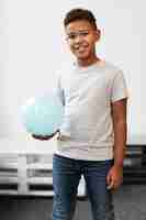 Free photo medium shot smiley boy holding ball