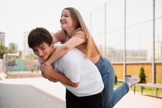 Medium shot smiley boy holding girl