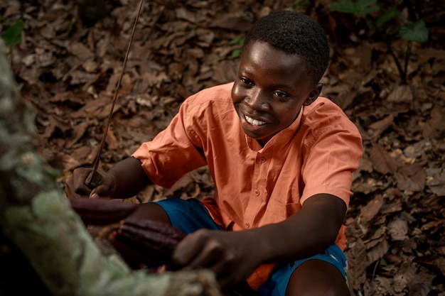 Medium shot smiley boy picking cocoa beans