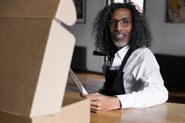 Medium shot smiley business owner sitting at table