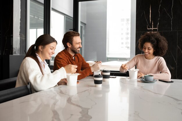 Medium shot smiley colleagues at table