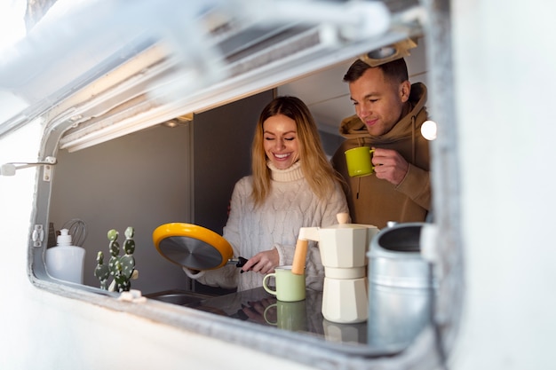 Free photo medium shot smiley couple in campervan