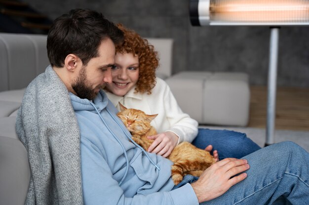 Medium shot smiley couple holding cat