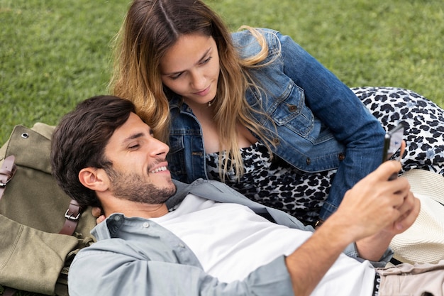 Medium shot smiley couple laying on grass