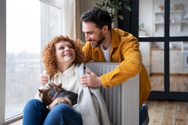 Medium shot smiley couple near heater