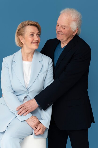 Medium shot smiley couple posing in studio