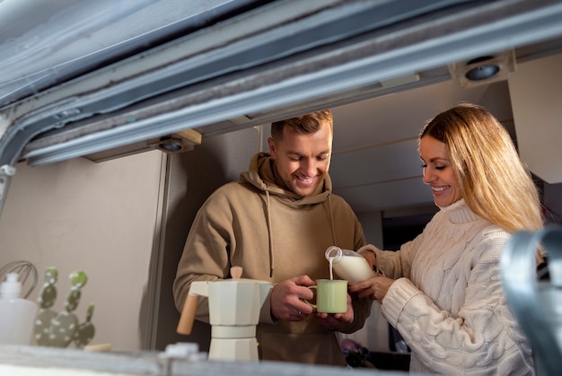 Medium shot smiley couple pouring milk