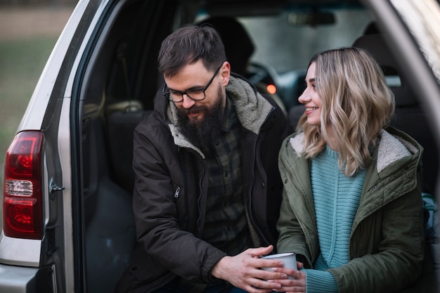 Medium shot smiley couple in van