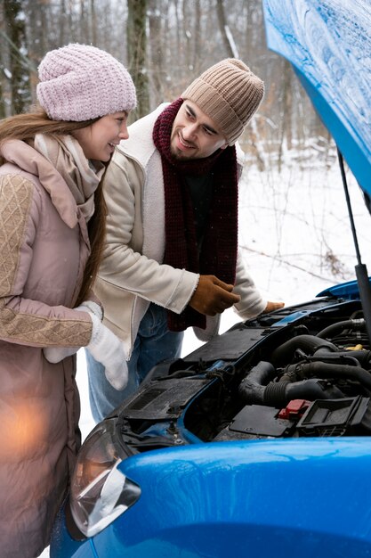 Medium shot smiley couple with car