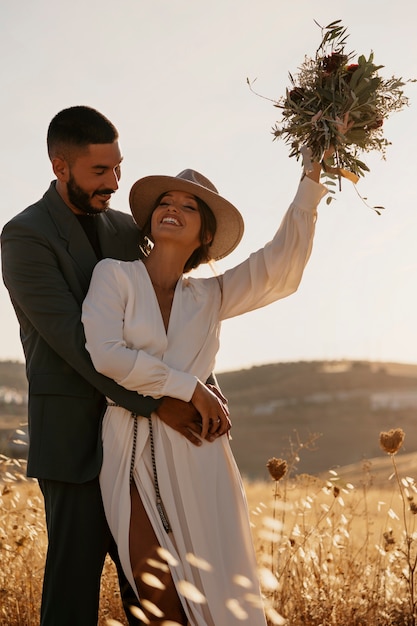 Free photo medium shot smiley couple with flowers