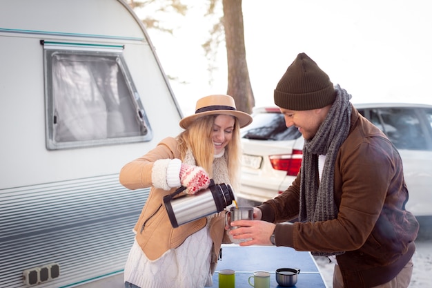 Medium shot smiley couple with hot beverage