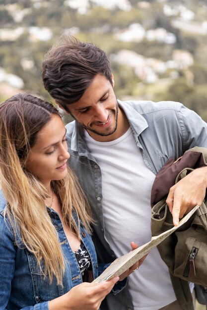 Free photo medium shot smiley couple with map