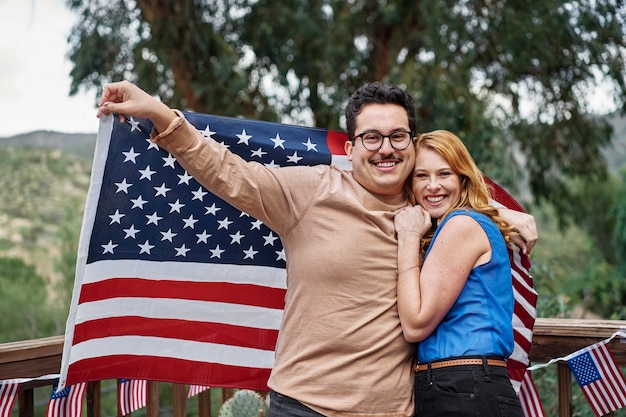 미국 국기와 함께 중간 샷 웃는 커플