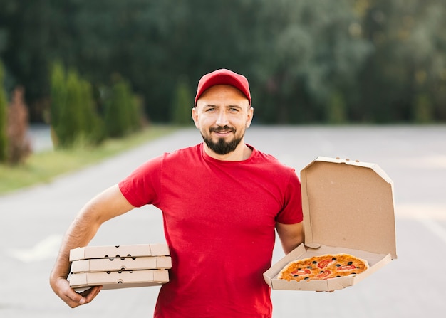 Uomo medio di consegna di smiley del colpo con pizza