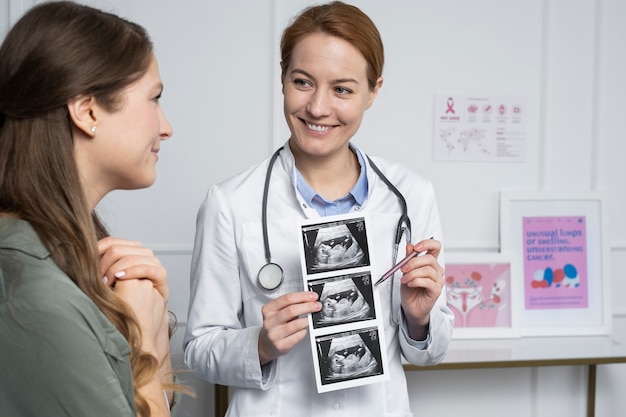 Free photo medium shot smiley doctor explaining ultrasounds