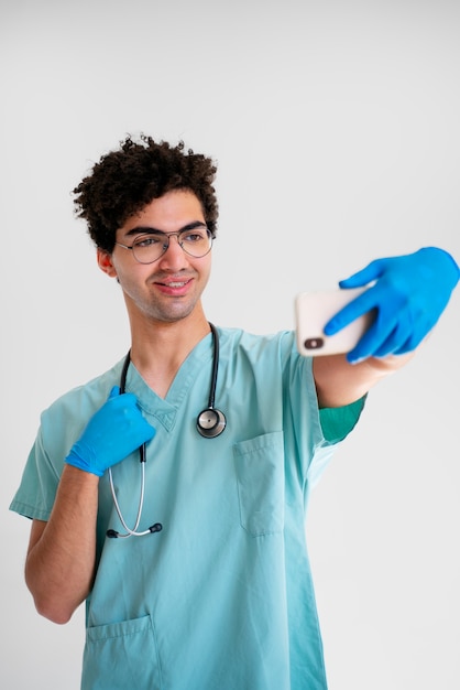 Medium shot smiley doctor taking selfie