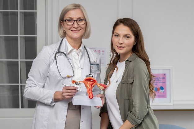 Medium shot smiley doctor and woman at clinic