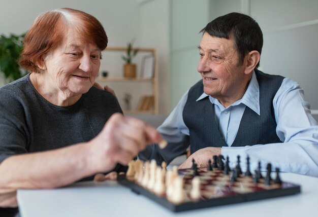 Medium shot smiley elderly playing chess