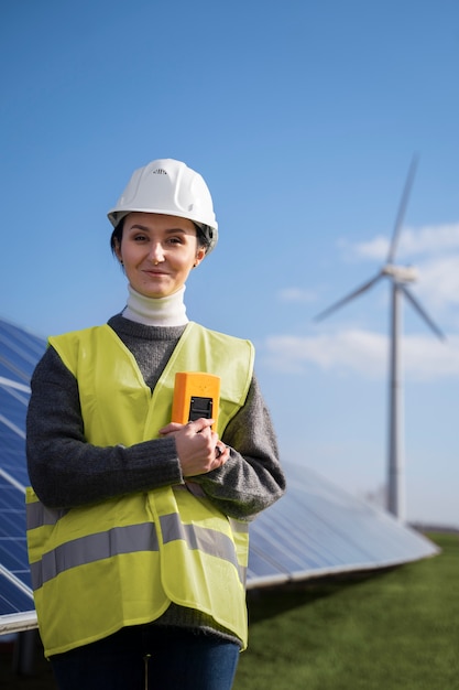 Medium shot smiley engineer wearing helmet outdoors