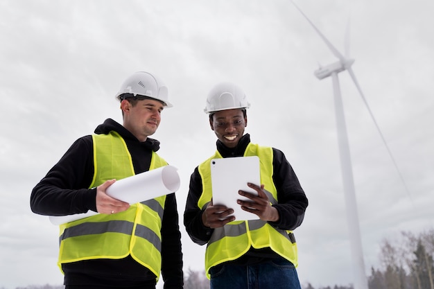 Free photo medium shot smiley engineers holding plan