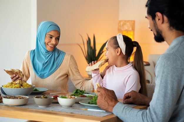 Medium shot smiley family eating together