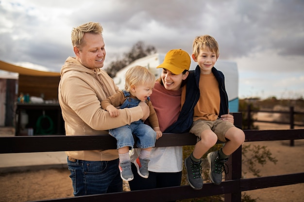 Foto gratuita famiglia sorridente del colpo medio all'aperto