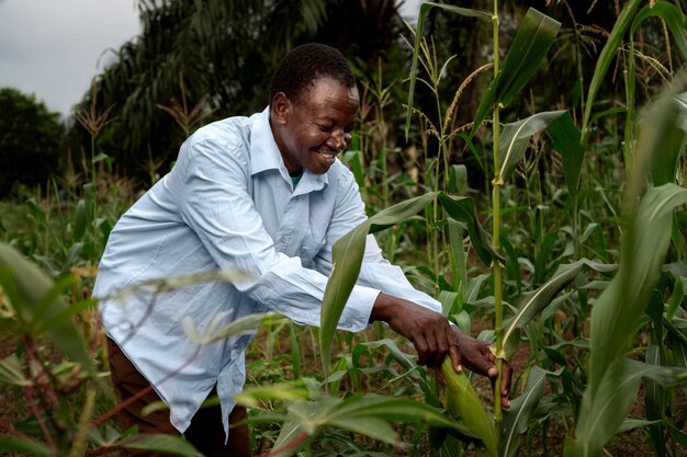 Medium shot smiley farmer in cornfield