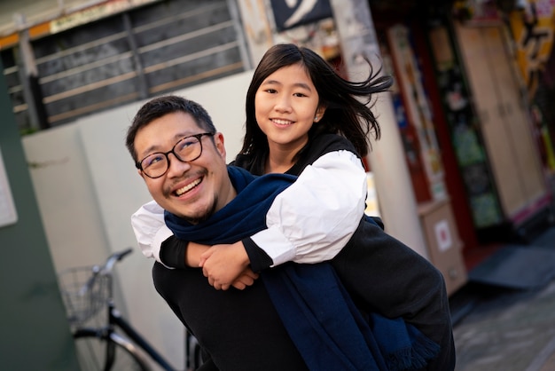 Foto gratuita padre sorridente a tiro medio che porta ragazza