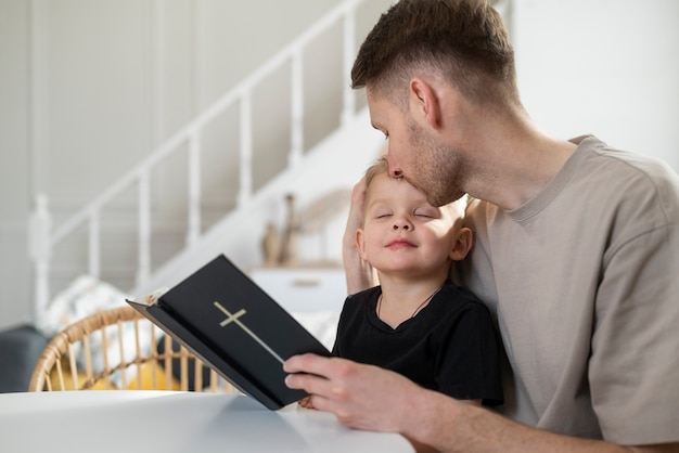 無料写真 ミディアムショットのスマイリー父が額に男の子にキス